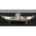 A silver plated inkwell stand, with central glass inkwell. 25cm long.