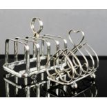 Two silver plated toast racks, one in the form of hearts.