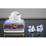 A porcelain Limoges Marques Depose trinket box with a cat form lid and a pair of ceramic flower