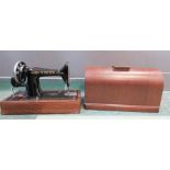 A hand operated sewing machine and case.