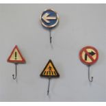 Four metal coat hooks in the form of road signs.