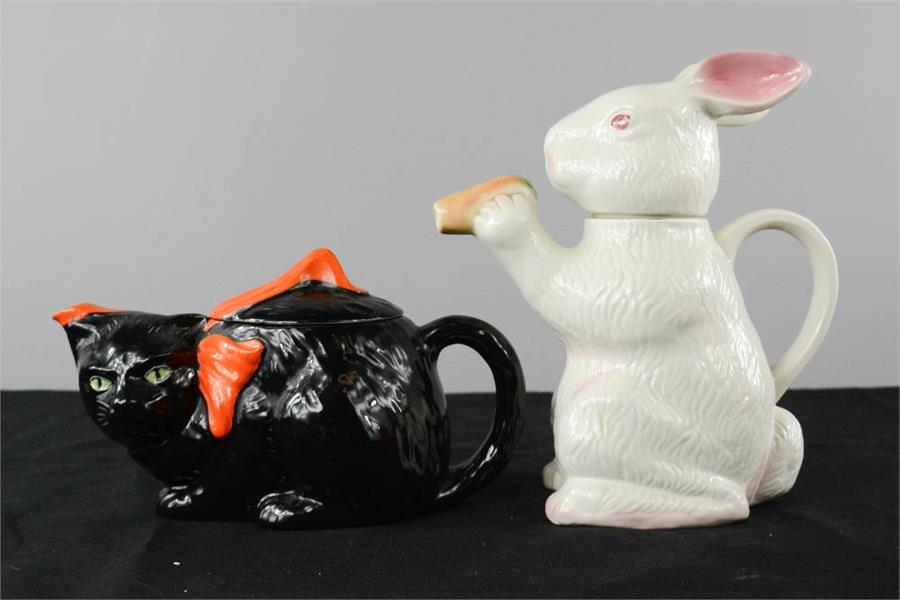 Two teapots, one in the form of a black cat, the other a rabbit.