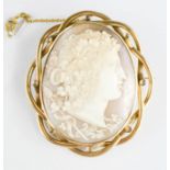 A cameo brooch depicting a winged male head set in a yellow gold mount, with an outer mount of