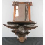 A Blackforest wall mirror / shelf depicting a carved eagle with a glass eye.