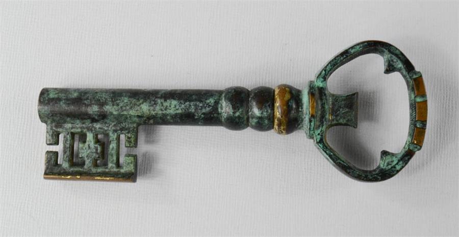 A bronze green patinated key form bottle opener.