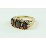 A 9ct gold ring set with three oval garnets, 4.2g.