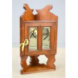 A small mahogany corner cabinet, with mirrored door, and shaped and pierced back.