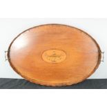 A large oval mahogany 19th century tray, with urn form marquetry oval to the centre and wavy edge.