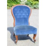 A Victorian nursing chair, upholstered in blue velvet, with button back.