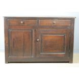 An early 18th century Scottish oak cupboard, with two drawers above a cupboard door and panel.