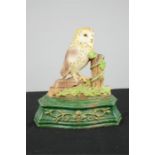 A cast iron doorstop in the form of an owl, painted with detail.