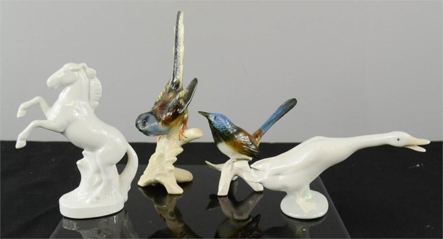 A porcelain Lladro goose, a Karl Ens bird, and two other figures.