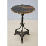 A 19th century ebonised table, with multifoil top, painted with a scene of a ruined castle in