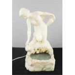 A marble lamp in the form of a nude woman collecting water.