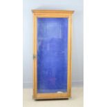 A glass display case, wall mounted with blue interior lining.