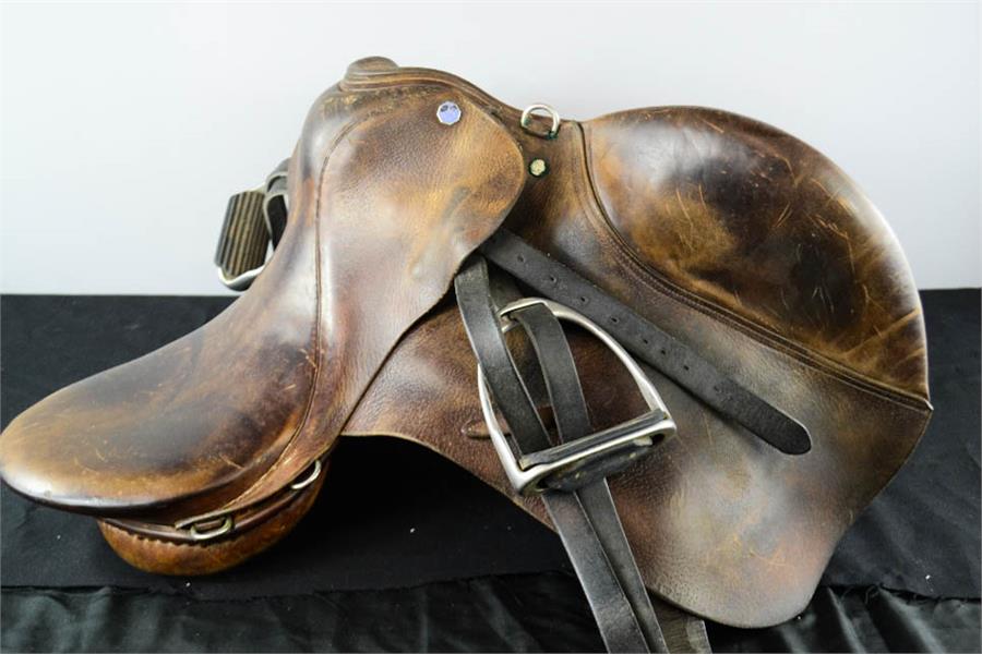 A leather riding saddle and girth.