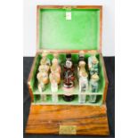 A 19th century chemists box in rosewood, green paper lined interior, containing original bottles