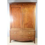 A Georgian mahogany linen cupboard, with two cupboard doors and drawers below.