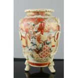A Japanese stoneware satsuma style vase, raised on three feet.
