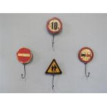 Four metal coat hooks in the form of road signs.