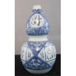 An Arabic blue and white Gourd vase, with text, 41cm high.