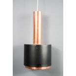 A Jo Hammerborg pendant light, with rose gold column and black shade.