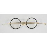 A pair of Edwardian spectacles with gold plated frames and black rims.