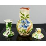 A candlestick and bud vase decorated with painted bees and a Torquay ware vase 15cm high.