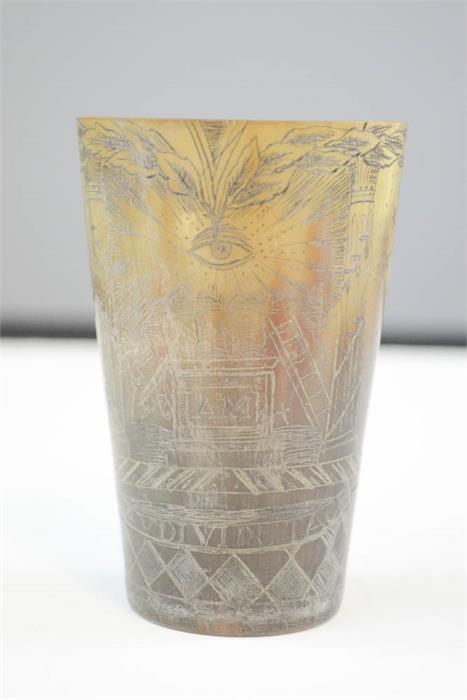 An early 19th century horn beaker engraved with symbols and other decoration. 9cm high.