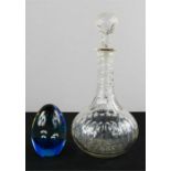 A glass decanter and a blue glass paperweight.