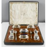 A silver cruet set, comprising two blue glass lined salts, salt and pepper shakers, two mustard, two