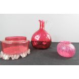 Two pieces cranberry glass together with a small Art glass vase.