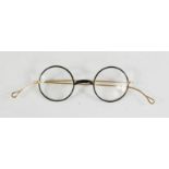 A pair of Edwardian spectacles with gold plated frames and black rims.