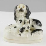 An early 19th century Staffordshire group; dog and puppy.