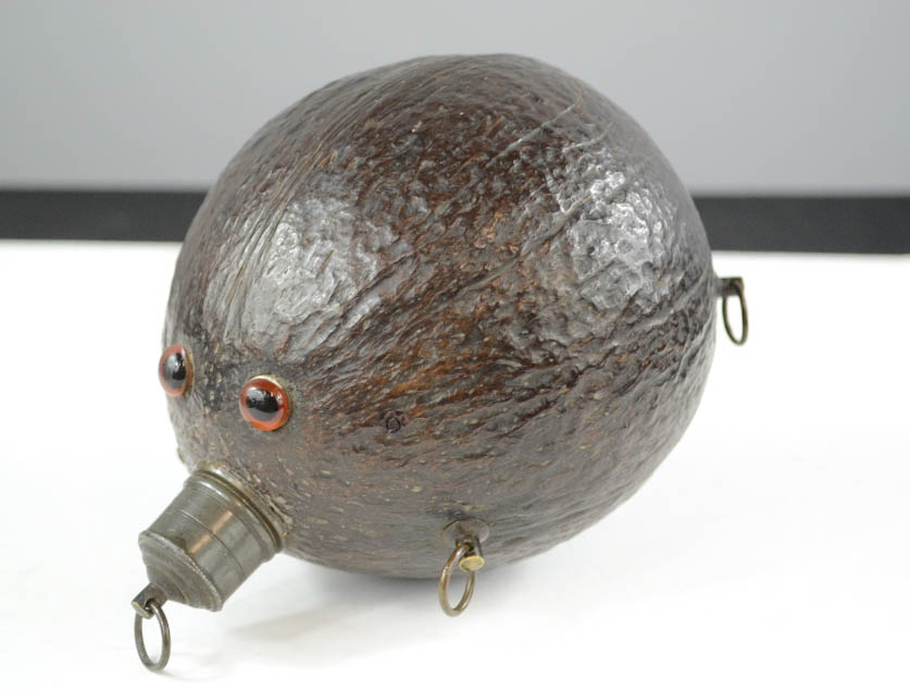 An antique coconut flask, inset with eyes.