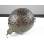 An antique coconut flask, inset with eyes.