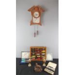 A group of model cars in display case, cuckoo clock, and other items.