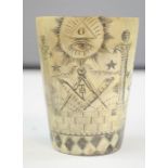 An early 19th century carved horn beaker, depicting masonic symbols. 7cm high.