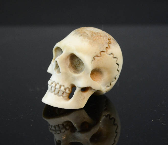 A miniature bone carved skull. 3½cm high.