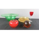 A group of glassware including an apple paperweight, a green glass bowl and other items.