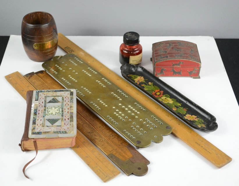 A brass cribbage board, mother of pearl bound bible, rules, papier mache pen stand, Japanese tin box