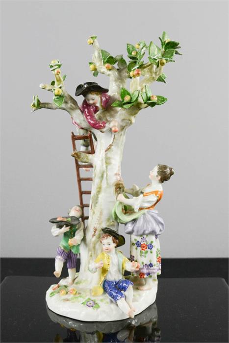 A Meissen 20th century figure group of young children playing in an apple tree, blue crossed sword