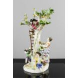 A Meissen 20th century figure group of young children playing in an apple tree, blue crossed sword