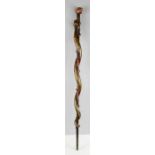 An early naive blacthorn carved walking stick carved with a snake and a skull form handle.