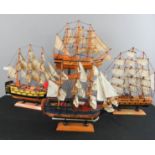 A group of four model sailing ships.