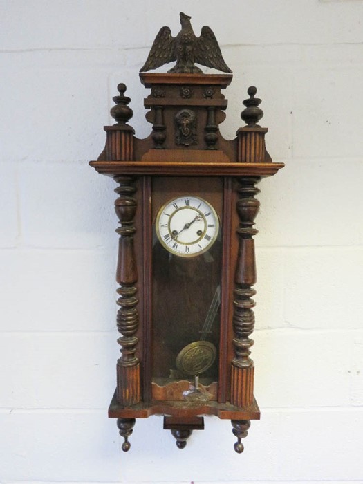 A Vienna wall clock, with gryphon, turned spindles and knobs, and key and pendulum.
