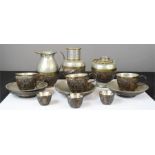 A Chinese coconut, pewter and white metal tea set comprising tea pot, tea bowls, water jug, cups and