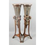 A pair of 19th century mahogany torcheres, the triform bases bearing rams head carvings and