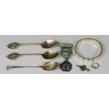 Three silver spoons, silver and mother of pearl bangle, and a rolled gold ring together with a