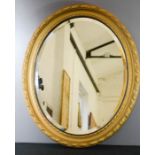 An oval giltwood wall mirror.